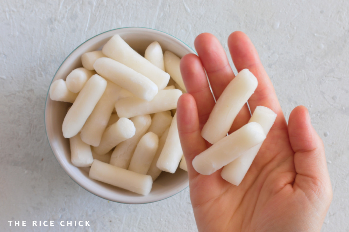 Korean rice cakes being held in a hand.