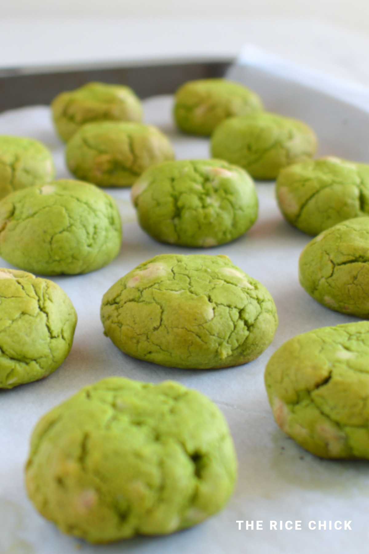 Matcha cookies on a baking tray with parchment paper.