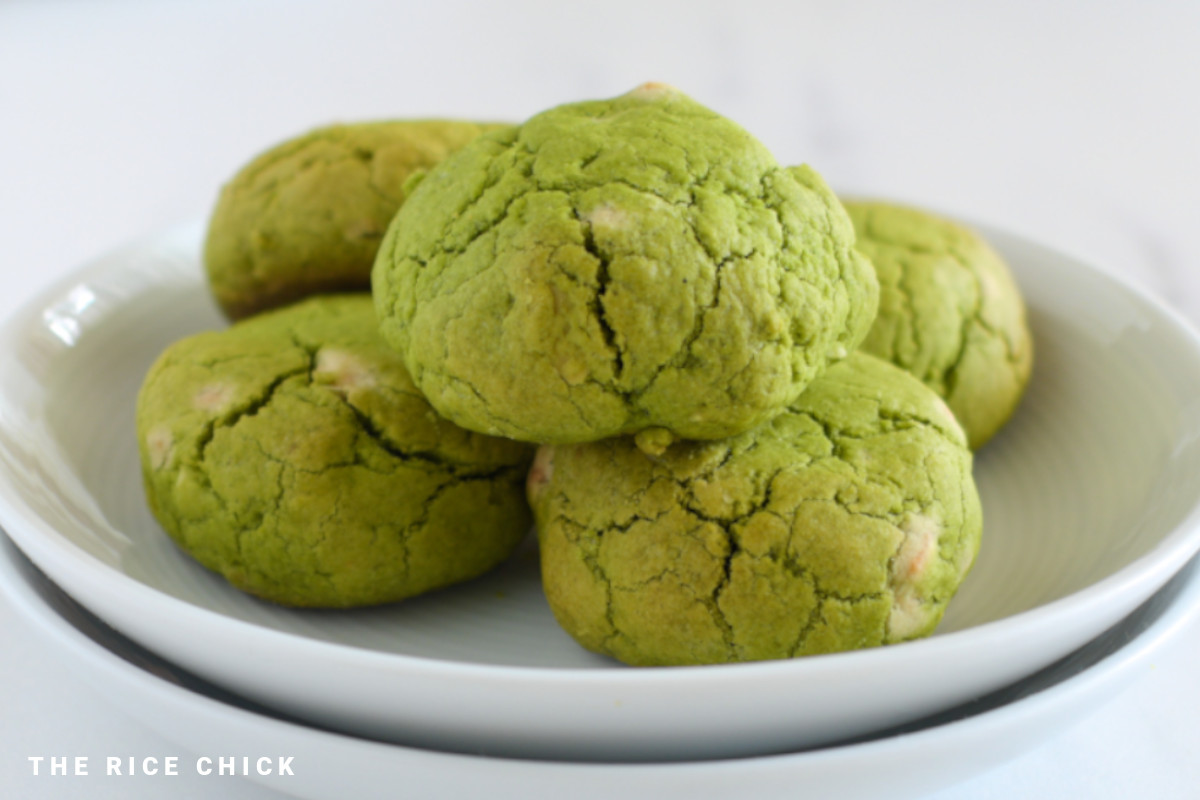 Matcha cookies stacked on top of each other on a white plate.