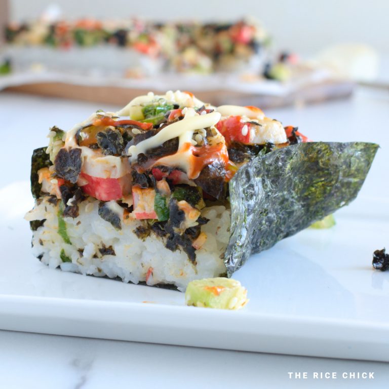 Baked sushi wrapped in nori (seaweed sheet) on a white plate.
