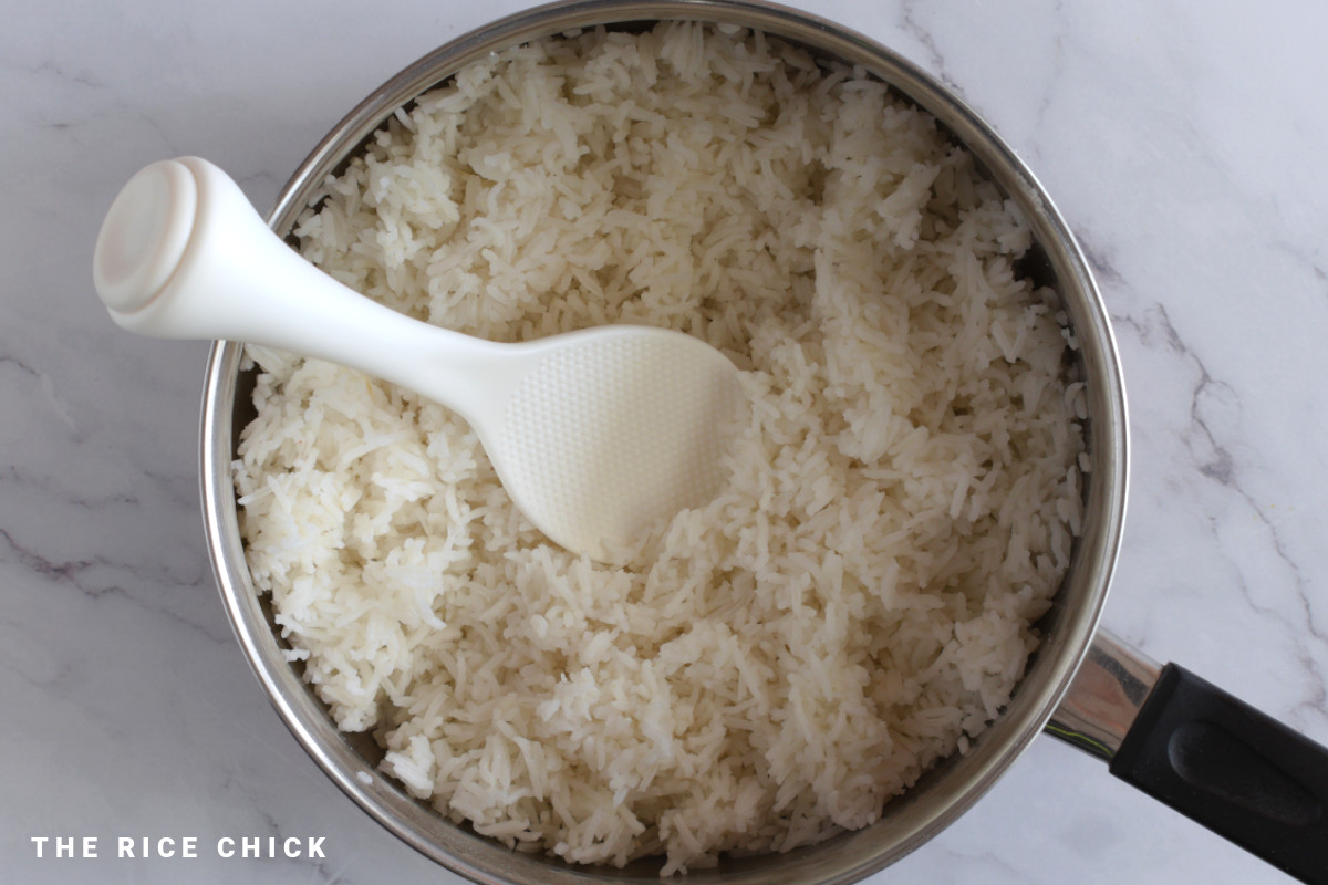 Cooked basmati rice in a pot, with a rice spoon.