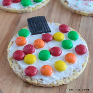 M&M Christmas rice cake ornament on a wooden board.