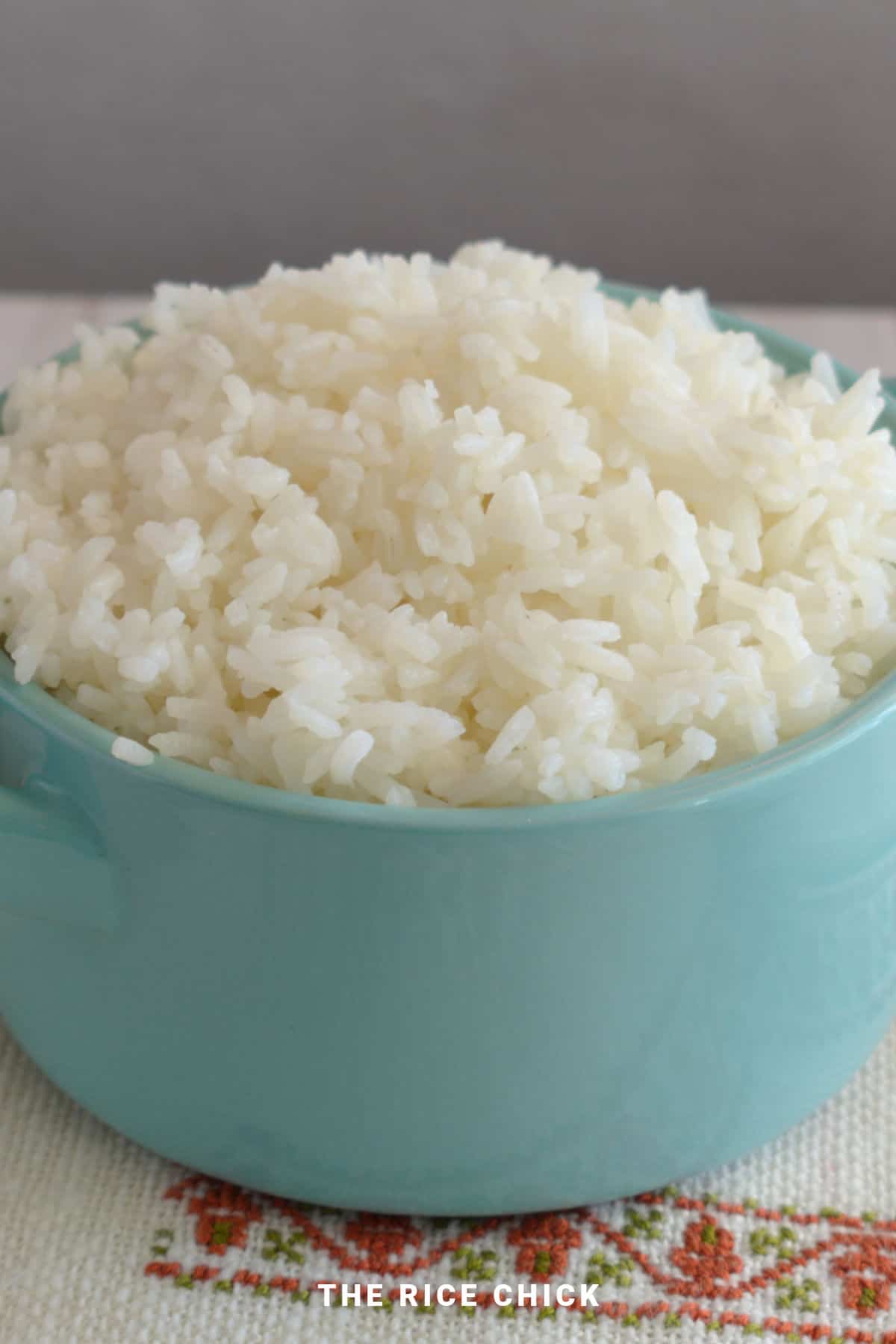 Close up image of cooked jasmine rice in a blue bowl.