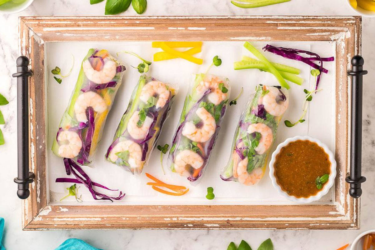 Fresh shrimp spring rolls on a serving board.
