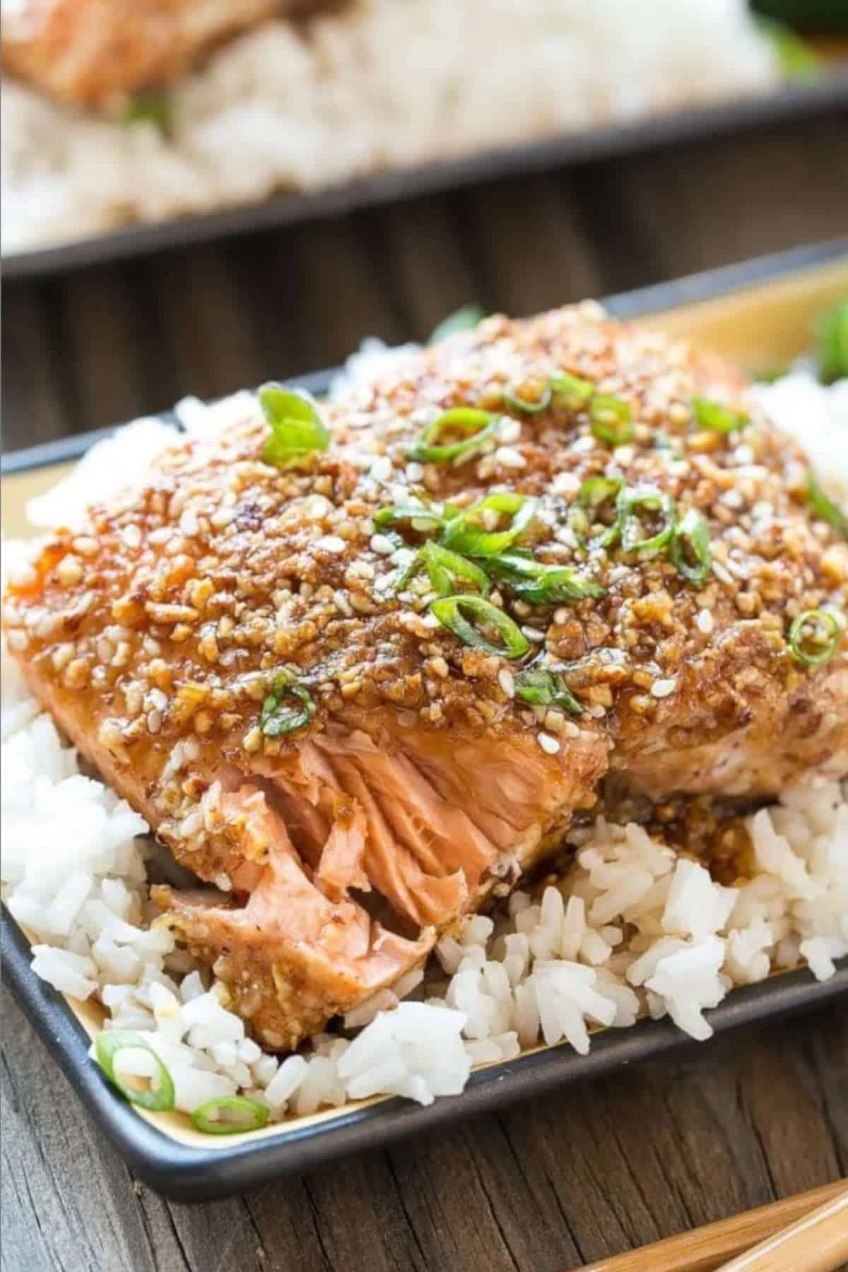 Almond crusted salmon on a bed of rice on a plate.