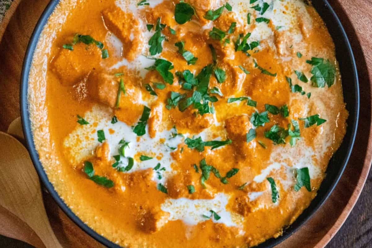 Close up image of butter chicken in a bowl.