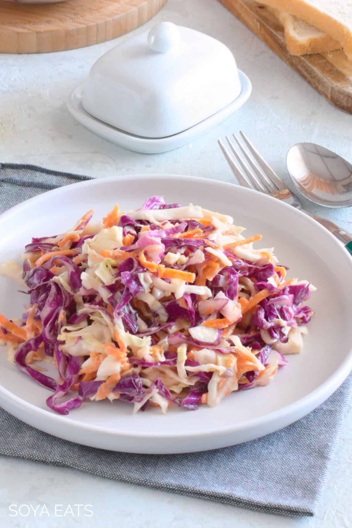Coleslaw on a white plate and grey napkin.