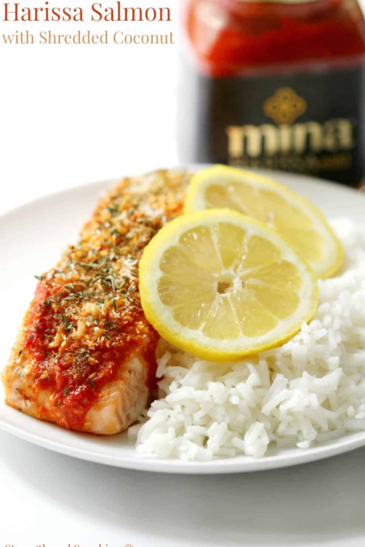 Harissa salmon on a plate with cooked rice and slices of lemon.