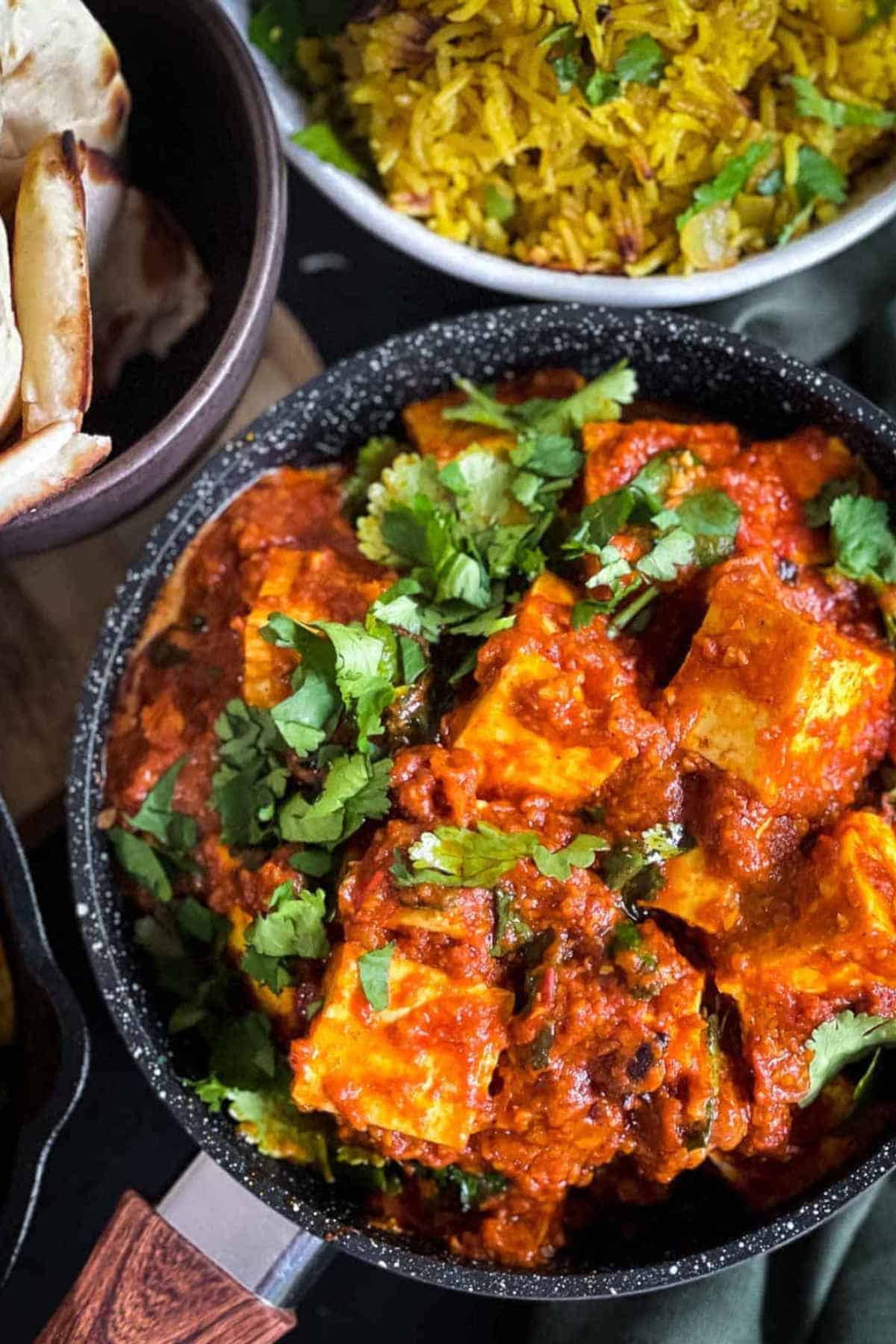 Close up image of paneer butter masala in a frying pan.