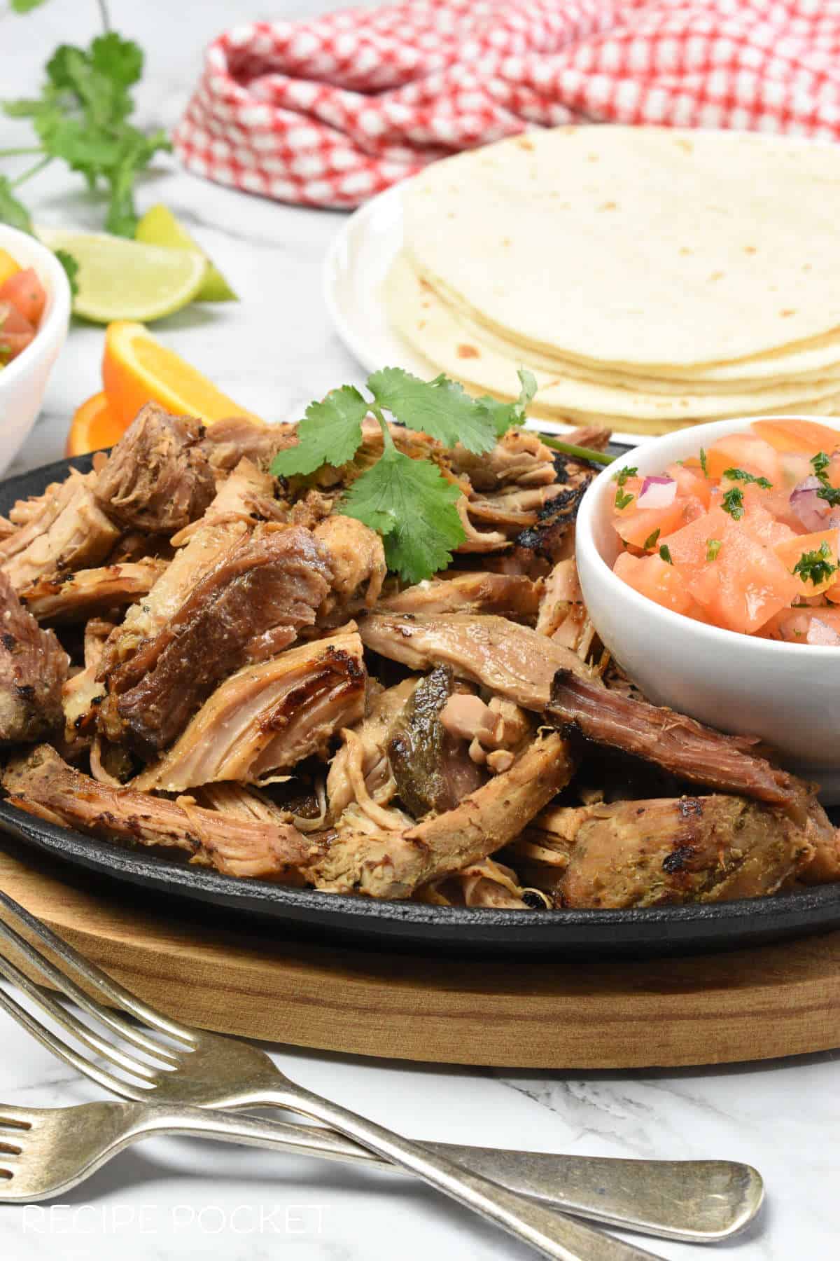 Close up image of slow cooker pulled pork on a black plate.