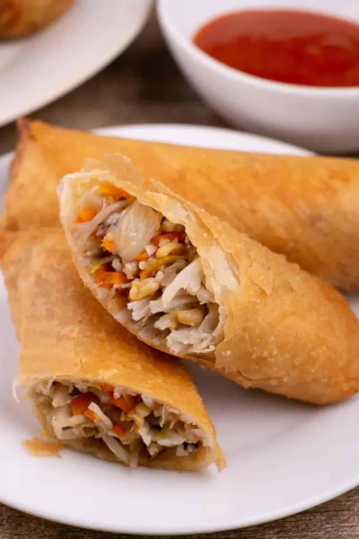 Close up image of cut egg rolls on a plate.