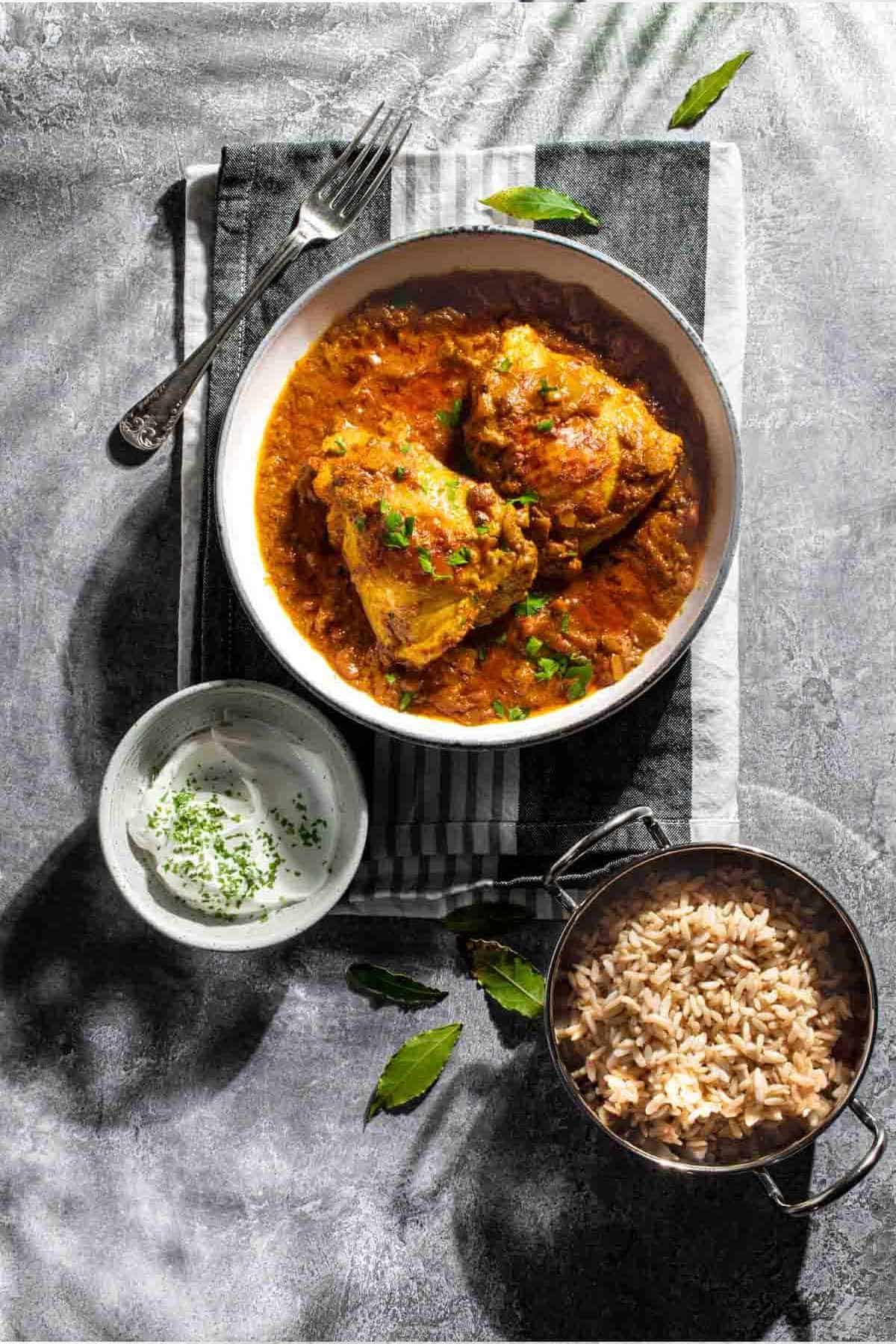 Nepalese chicken in a bowl on a grey tea towel.