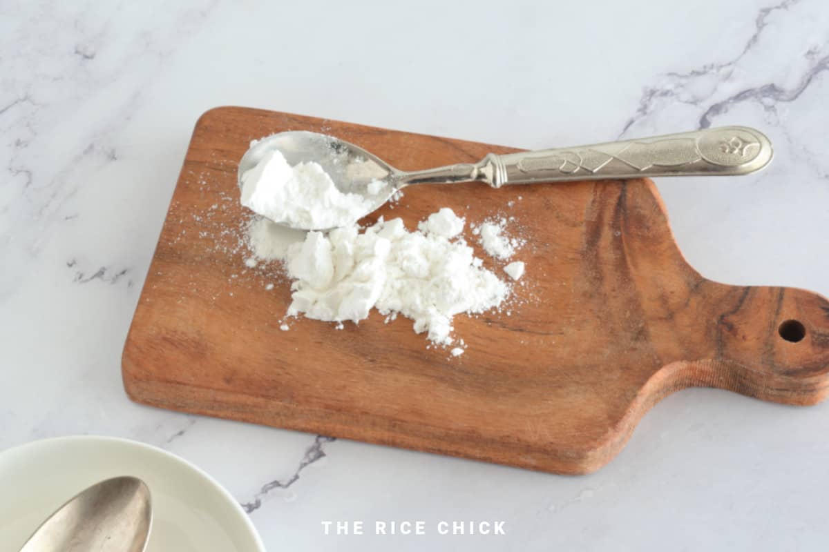 Rice flour on a wooden board with a spoon.