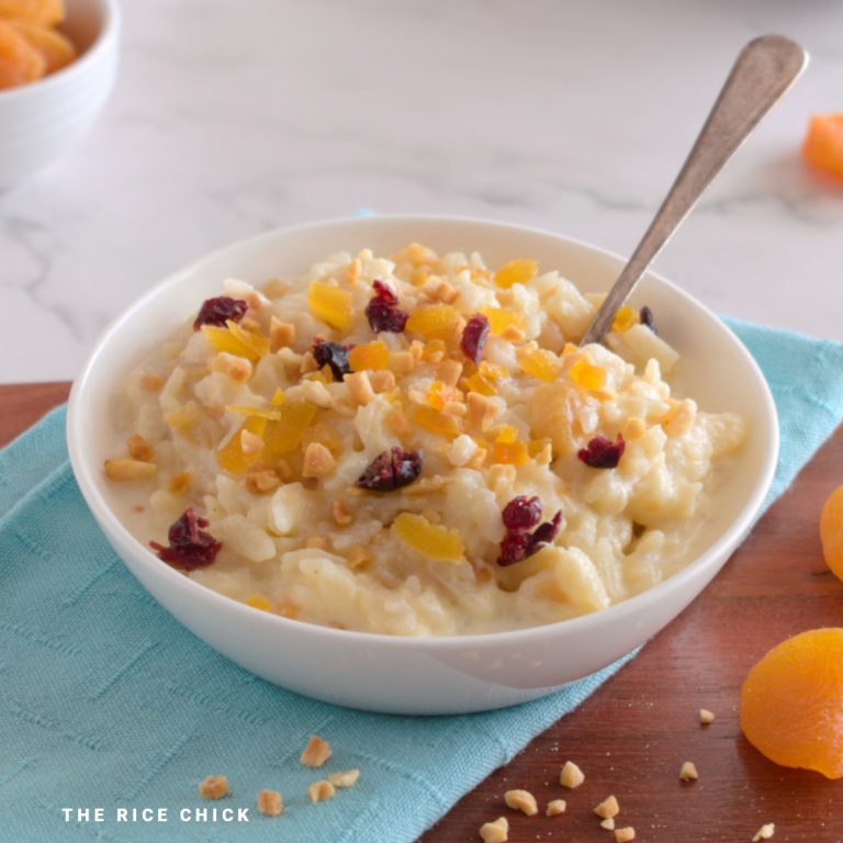 Flaked rice pudding in a bowl, topped with dried fruit and nuts.