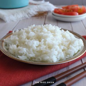 Cooked jasmine rice on a plate on a red napkin.