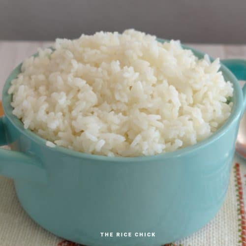 Cooked jasmine rice in a blue bowl with handles.