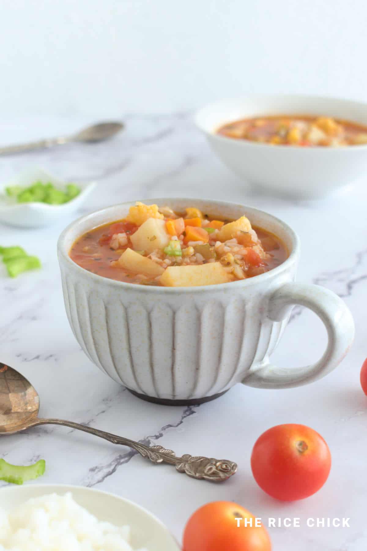 Vegetable rice soup in a grey mug.
