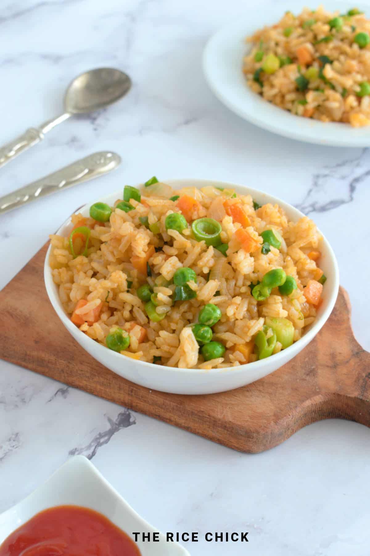 Fried rice in a bowl on a wooden board.