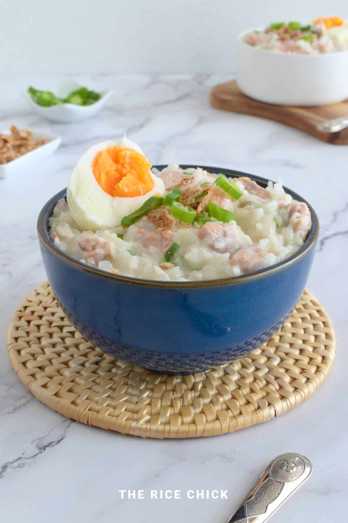 Salmon congee in a blue bowl.