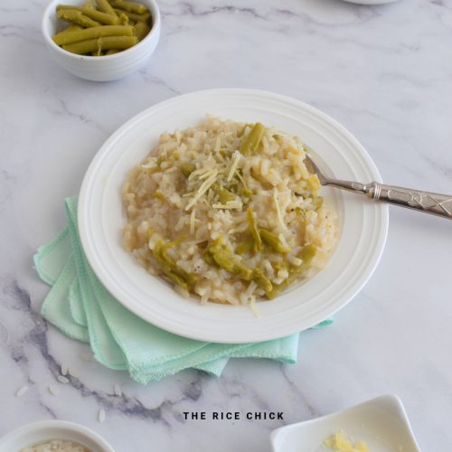 Close up image of asparagus risotto on a white plate with a spoon.